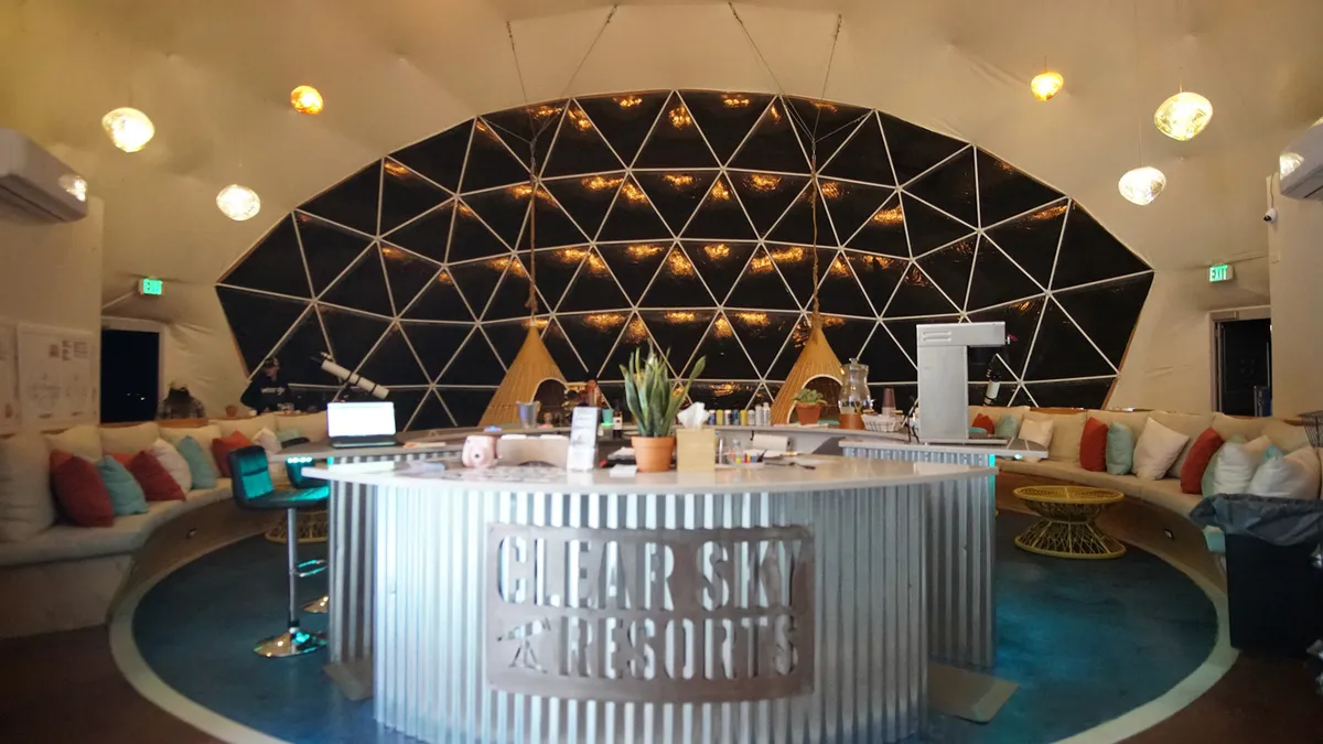 A circular reception desk inside a spacious resort dome