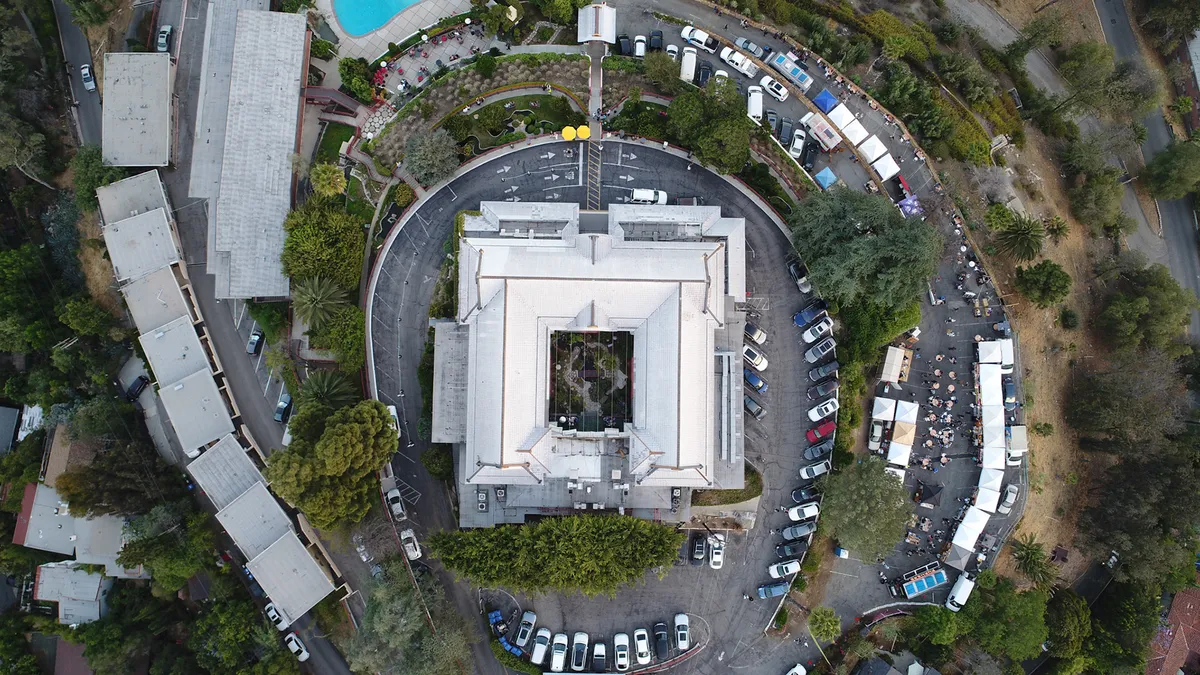 A straight-down aerial view of a building surrounded by a circular road