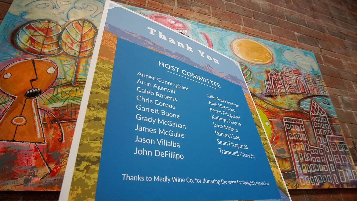 An event thank-you sign against a colorful painted wall